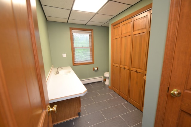 296 Atwood Rd, Duxbury, VT 05676 - bathroom with a baseboard radiator, toilet, vanity, tile patterned floors, and a paneled ceiling