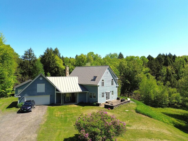 296 Atwood Rd, Duxbury, VT 05676 - view of front of home featuring driveway, a garage, a front lawn, and a chimney