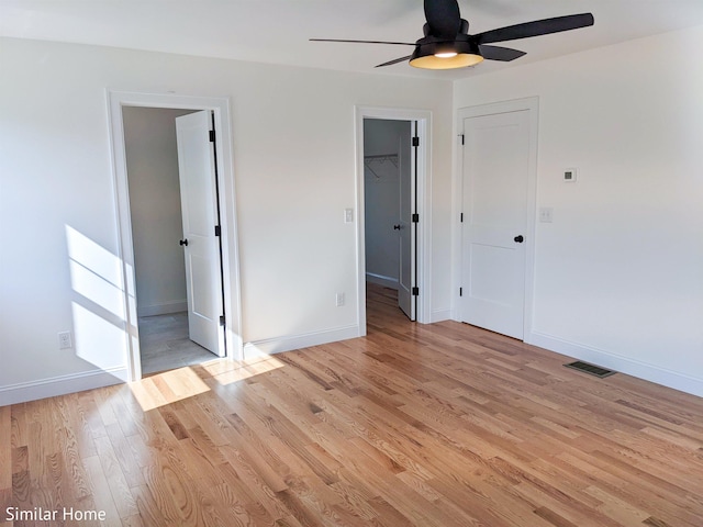 LOT7-3 Sanborn Mdw Unit 7-3, Fremont, NH 03044 - unfurnished bedroom featuring light wood-type flooring, baseboards, a walk in closet, and a closet