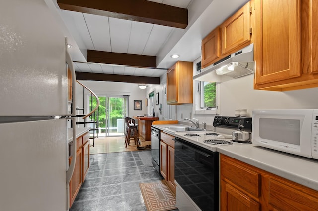 180 Ash St, Conway, NH 03860 - kitchen with white appliances, under cabinet range hood, a sink, light countertops, and brown cabinetry