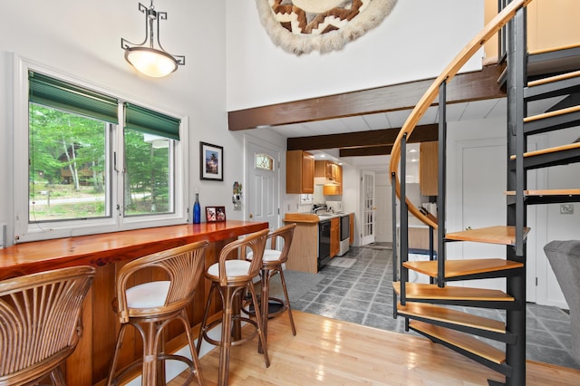 180 Ash St, Conway, NH 03860 - indoor dry bar featuring range, stairway, beam ceiling, and wood finished floors