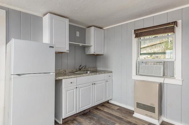 522 Ocean Blvd Unit 10, Hampton, NH 03842 - kitchen featuring freestanding refrigerator, a sink, heating unit, dark wood-style flooring, and white cabinets