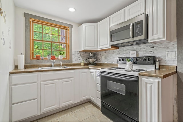 290 Cornish Tpke, Newport, NH 03773 - kitchen featuring range with electric stovetop, stainless steel microwave, a sink, white cabinetry, and decorative backsplash