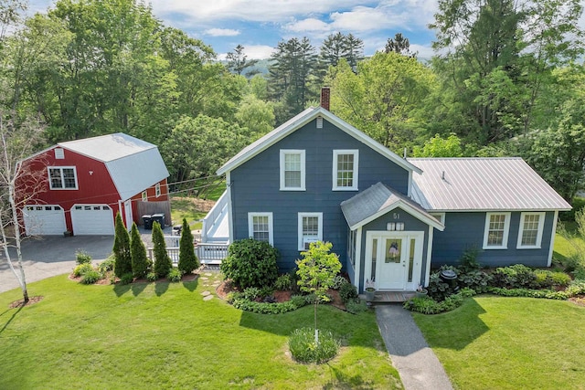 51 May St, Enfield, NH 03748 - view of front facade with an outdoor structure, a garage, a front yard, a chimney, and a barn