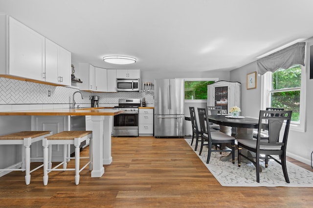 414 Blueberry Ln, Conway, NH 03860 - kitchen featuring stainless steel appliances, a peninsula, plenty of natural light, and wood counters