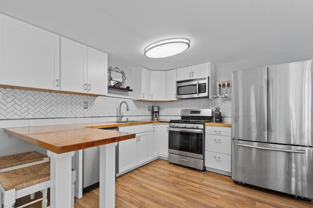 414 Blueberry Ln, Conway, NH 03860 - kitchen with stainless steel appliances, wooden counters, a sink, open shelves, and tasteful backsplash