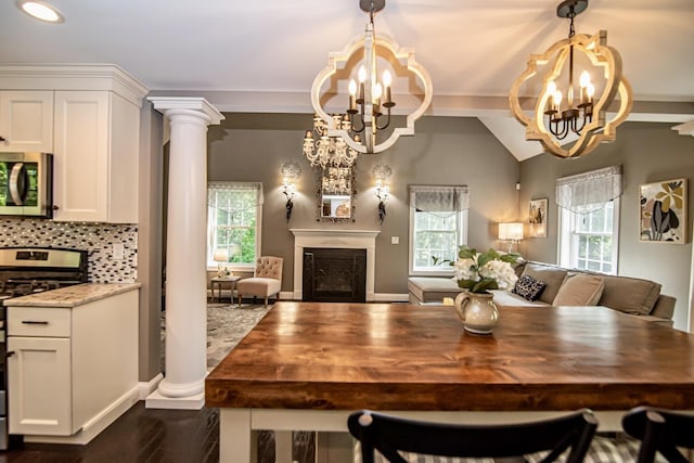 4 Crossman Cir, Newton, NH 03858 - dining area with a chandelier, a fireplace, plenty of natural light, dark wood-style flooring, and vaulted ceiling