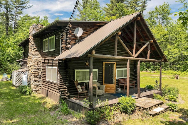 230 Pine Hill Rd, Ossipee, NH 03864 - cabin with log exterior, a wooden deck, a front lawn, a chimney, and metal roof