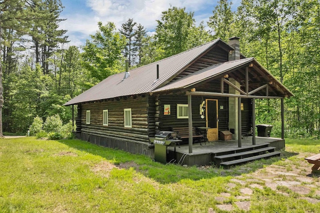 230 Pine Hill Rd, Ossipee, NH 03864 - back of house with a chimney, log siding, a lawn, a wooden deck, and metal roof