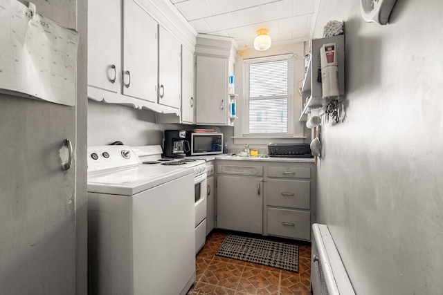 33 Hayes Ave, Manchester, NH 03103 - kitchen with stainless steel microwave, light countertops, white cabinetry, a baseboard radiator, and dark tile patterned floors