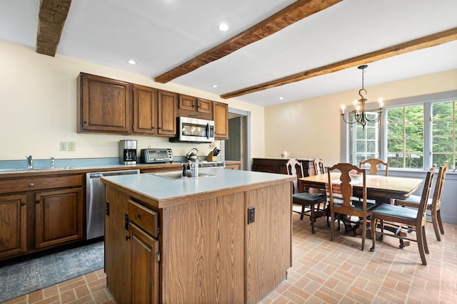 183 Mountain View Rd, Whitefield, NH 03598 - kitchen with stainless steel appliances, a sink, beamed ceiling, brick patterned floors, and decorative light fixtures