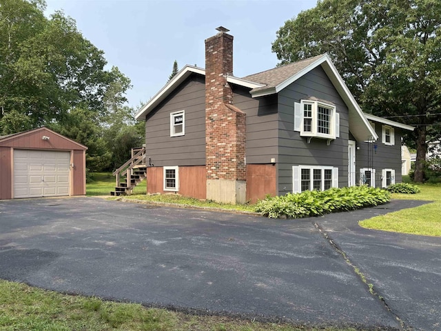 4 Mount Vernon Dr, Pelham, NH 03076 - view of side of property featuring an outbuilding, asphalt driveway, a garage, and a chimney