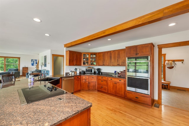 190 Ledge Hill Rd, Tuftonboro, NH 03816 - kitchen featuring stainless steel appliances, a sink, brown cabinetry, glass insert cabinets, and recessed lighting
