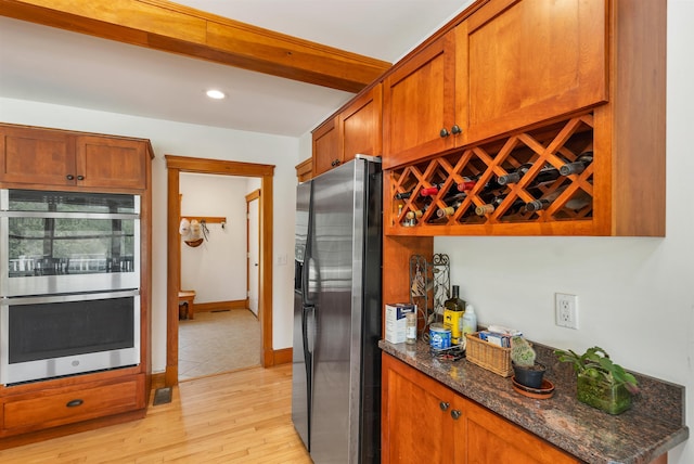 190 Ledge Hill Rd, Tuftonboro, NH 03816 - kitchen featuring stainless steel appliances, brown cabinets, dark stone counters, light wood finished floors, and recessed lighting