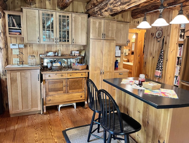 27 Stearns Ave, Wilmington, VT 05363 - kitchen featuring wooden walls, light wood-type flooring, a kitchen breakfast bar, glass insert cabinets, and a kitchen island
