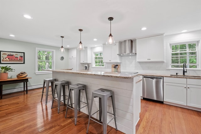 6 Bona Vista Dr, Bow, NH 03304 - kitchen with stainless steel dishwasher, wall chimney exhaust hood, a sink, a breakfast bar, and light wood finished floors