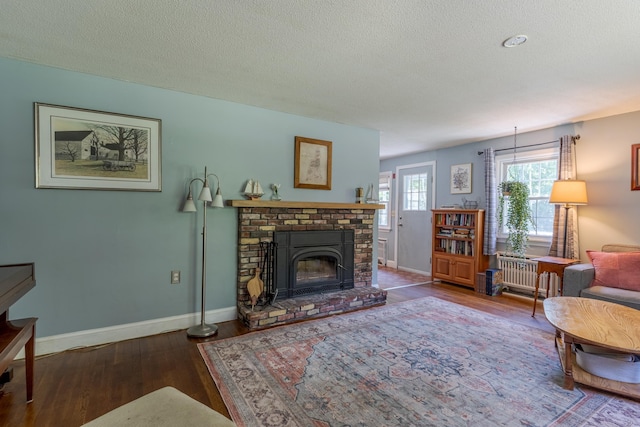 15 Allens Ave, Lee, NH 03861 - living area with wood-type flooring, baseboards, a fireplace, and a textured ceiling