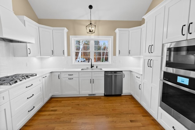 70 Hatch Corner Rd, Meredith, NH 03253 - kitchen with stainless steel appliances, custom range hood, a sink, vaulted ceiling, and white cabinets