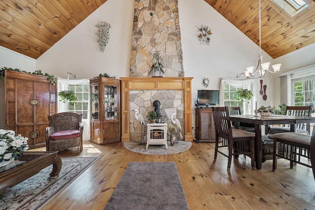 109 Temple Rd, Wilton, NH 03086 - living area with high vaulted ceiling, wood-type flooring, a wood stove, a chandelier, and wood ceiling