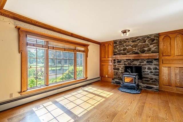 98 Sugar Maple Dr, Swanton, VT 05488 - unfurnished living room with a wood stove, a baseboard radiator, healthy amount of natural light, and light wood-style floors