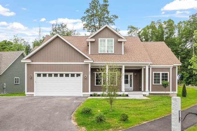 288 Sterling Dr, Laconia, NH 03249 - view of front facade with a garage, driveway, covered porch, a front yard, and a shingled roof