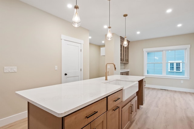 288 Sterling Dr, Laconia, NH 03249 - kitchen with a sink, light wood-style flooring, baseboards, a kitchen island with sink, and recessed lighting