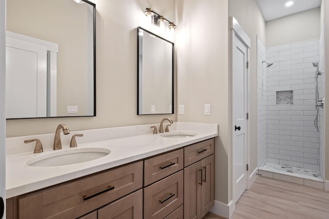 288 Sterling Dr, Laconia, NH 03249 - bathroom with double vanity, a tile shower, wood finished floors, baseboards, and recessed lighting