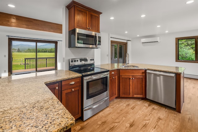 210 Field Rd Unit 44, Stowe, VT 05672 - kitchen with stainless steel appliances, a sink, a peninsula, a wall mounted AC, and light stone counters