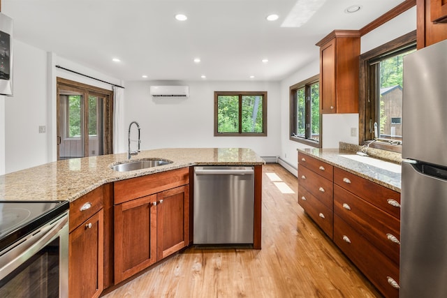 210 Field Rd Unit 44, Stowe, VT 05672 - kitchen featuring stainless steel appliances, an AC wall unit, light wood finished floors, a sink, and recessed lighting