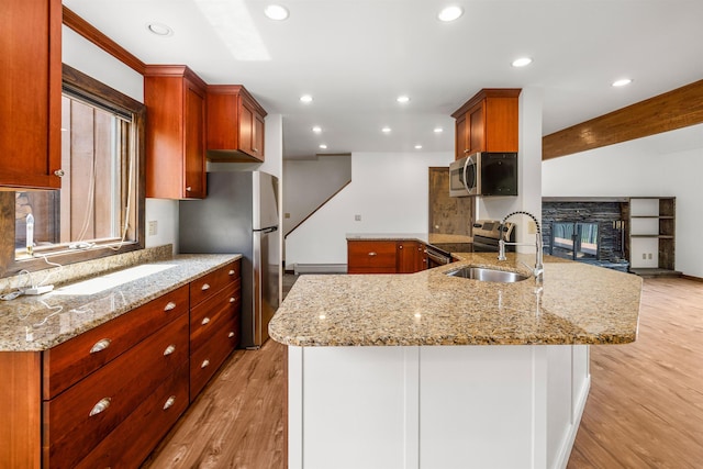 210 Field Rd Unit 44, Stowe, VT 05672 - kitchen with appliances with stainless steel finishes, light wood finished floors, light stone counters, recessed lighting, and a sink