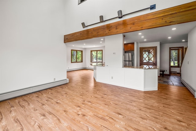 210 Field Rd Unit 44, Stowe, VT 05672 - unfurnished living room featuring light wood-style floors, a baseboard radiator, recessed lighting, and baseboards