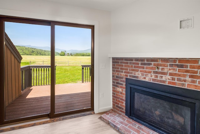 210 Field Rd Unit 44, Stowe, VT 05672 - entryway featuring a fireplace, wood finished floors, a view of countryside, a mountain view, and baseboards