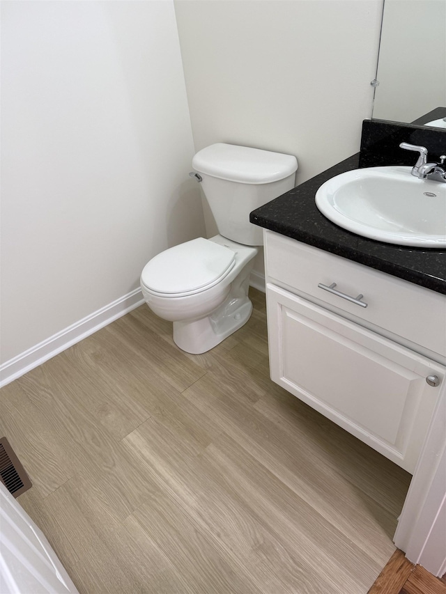 106 Karatzas Ave, Manchester, NH 03104 - bathroom with vanity, toilet, wood finished floors, and baseboards