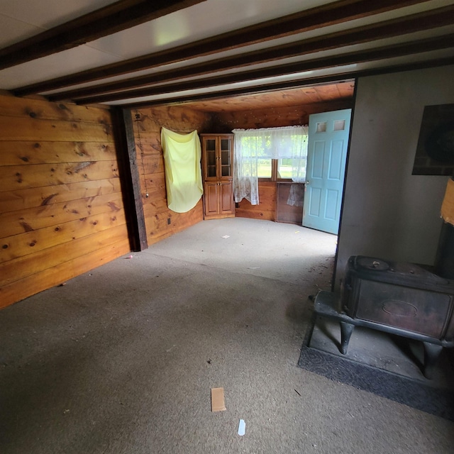 167 Branch Londonderry Tpke, Hopkinton, NH 03229 - unfurnished living room featuring a wood stove, beamed ceiling, carpet floors, and wood walls
