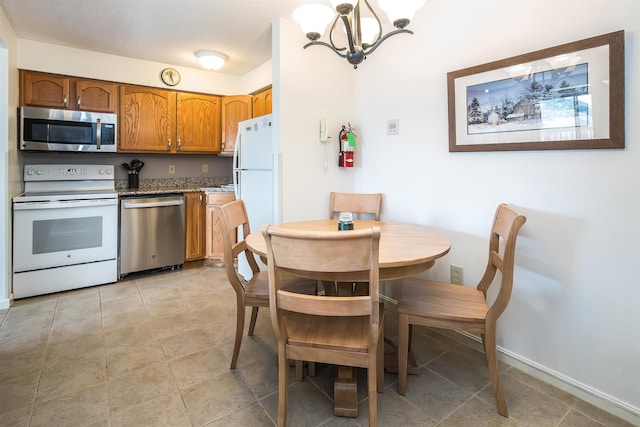 133 E Mountain Rd Unit 3D13, Killington, VT 05751 - kitchen featuring appliances with stainless steel finishes, a chandelier, brown cabinetry, and baseboards