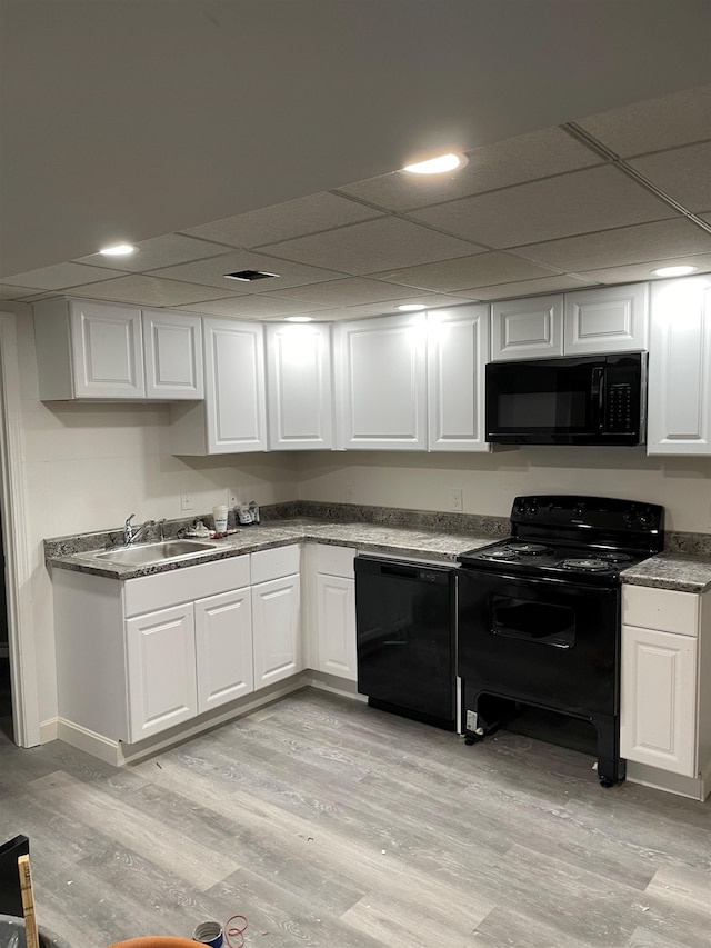 26 W Webster St, Manchester, NH 03104 - kitchen with black appliances, white cabinetry, light wood-type flooring, a sink, and a drop ceiling