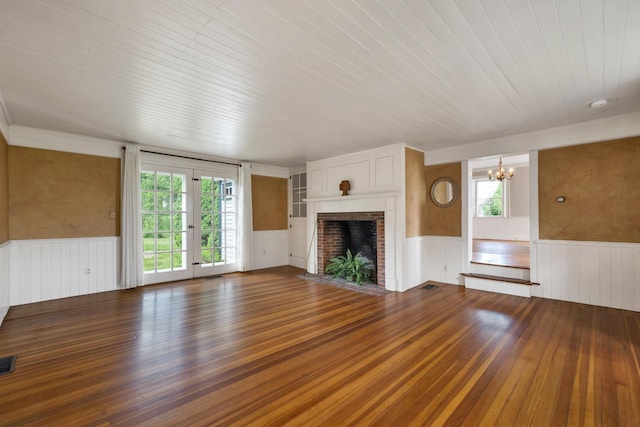 1519 New Boston Rd, Francestown, NH 03043 - unfurnished living room with wainscoting, a chandelier, wood finished floors, wood ceiling, and a brick fireplace