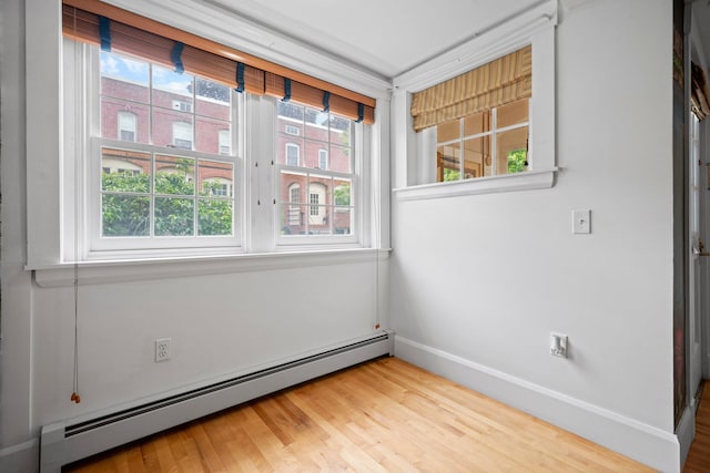 647 Canal St, Manchester, NH 03101 - empty room with a baseboard heating unit, wood finished floors, and baseboards