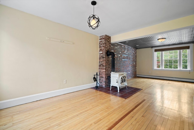 647 Canal St, Manchester, NH 03101 - living room featuring a baseboard heating unit, hardwood / wood-style flooring, a wood stove, and baseboards