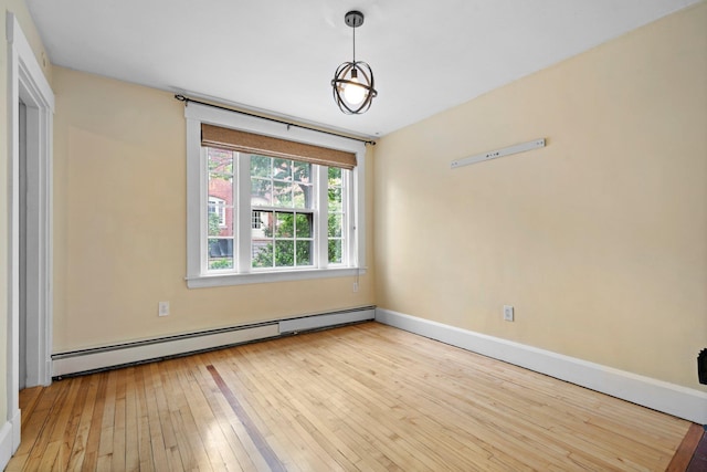 647 Canal St, Manchester, NH 03101 - unfurnished room with baseboard heating, hardwood / wood-style flooring, and baseboards