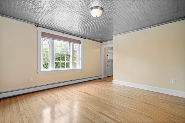 647 Canal St, Manchester, NH 03101 - unfurnished room featuring a baseboard heating unit, baseboards, and hardwood / wood-style floors