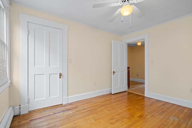 647 Canal St, Manchester, NH 03101 - unfurnished bedroom featuring a baseboard radiator, ornamental molding, light wood-style flooring, baseboards, and a ceiling fan