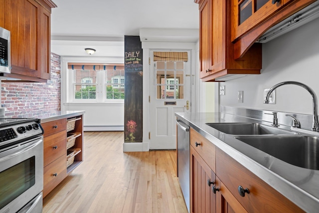 647 Canal St, Manchester, NH 03101 - kitchen with stainless steel appliances, baseboard heating, stainless steel countertops, a sink, and brown cabinets