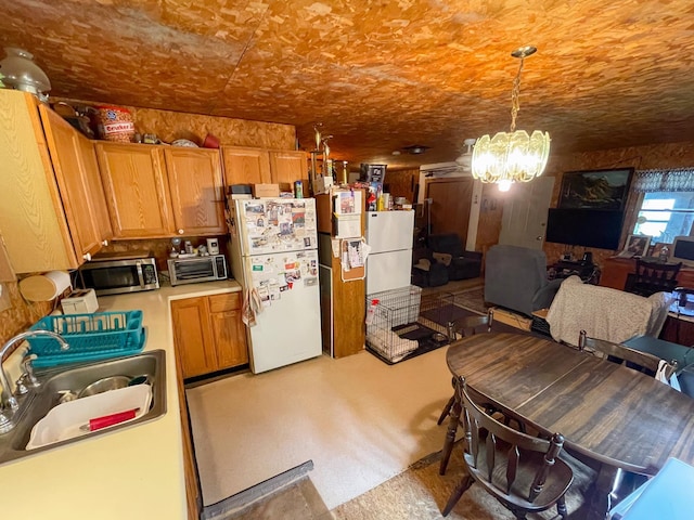 4823 Swamp Rd, Newbury, VT 05051 - kitchen with freestanding refrigerator, stainless steel microwave, a sink, a chandelier, and light countertops