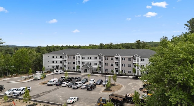 10100 S Willow St Unit 105, Manchester, NH 03103 - view of building exterior with uncovered parking and a forest view