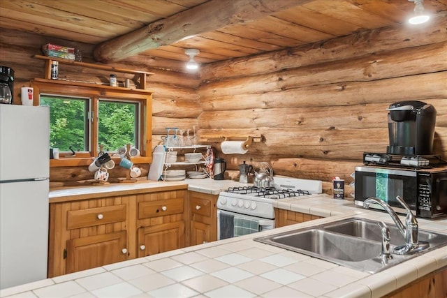 458 Woodcock Rd, Plainfield, VT 05667 - kitchen featuring white appliances, tile countertops, wooden ceiling with exposed beams, rustic walls, and a sink