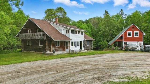458 Woodcock Rd, Plainfield, VT 05667 - view of front of house featuring a chimney, a detached garage, a front yard, and driveway