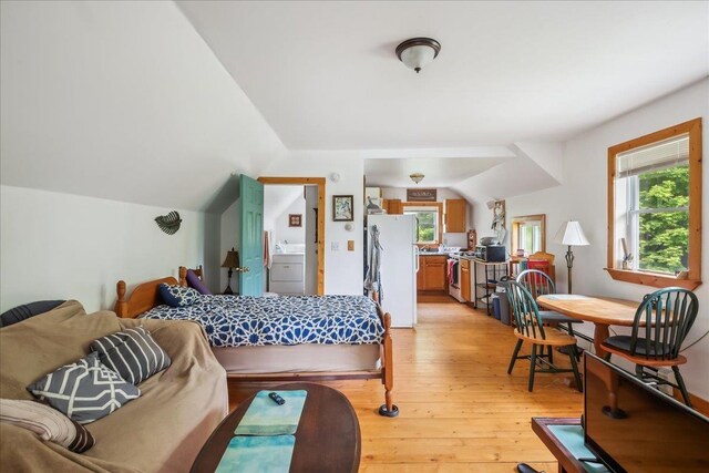 458 Woodcock Rd, Plainfield, VT 05667 - bedroom with freestanding refrigerator, multiple windows, light wood-type flooring, and vaulted ceiling