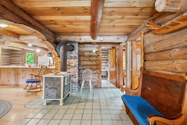 458 Woodcock Rd, Plainfield, VT 05667 - dining space featuring log walls, a wood stove, wood ceiling with exposed beams, and light tile patterned floors