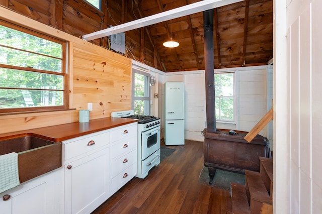 31 Sherene Orchard Rd, Meredith, NH 03253 - kitchen featuring a wood stove, white appliances, dark wood-style floors, vaulted ceiling, and white cabinetry
